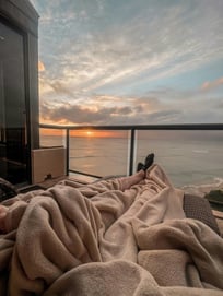 Terrazza vista mare al tramonto con letto accogliente per un’esperienza relax Day Use in hotel