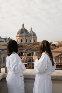 Due donne in accappatoio con vista città durante un soggiorno Day Use esclusivo in hotel